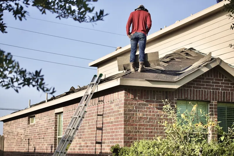 Professional roofer working on a residential roof in Allison